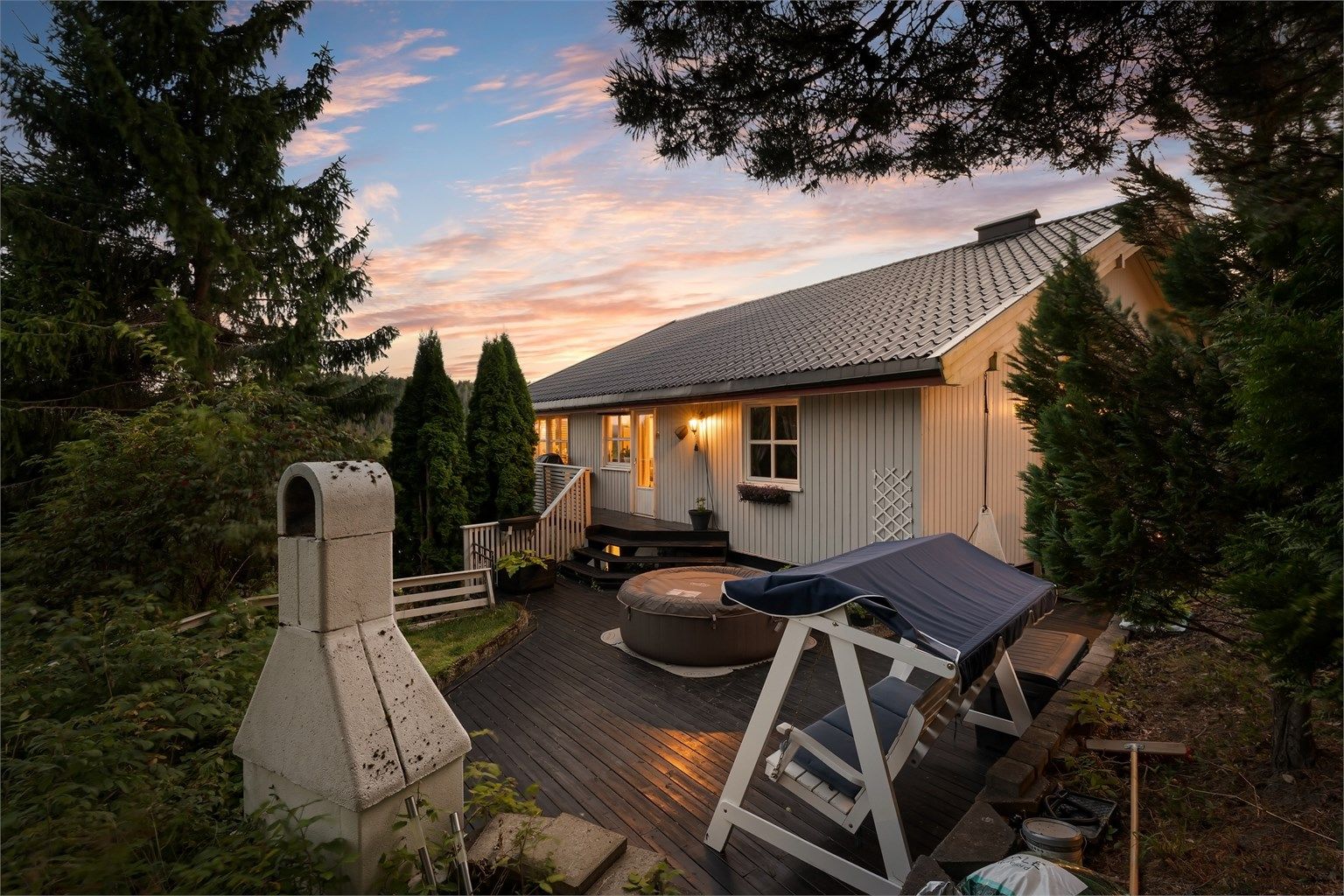 Tomten er opparbeidet med flere uteplasser i terrenget, som her med markterrasse i tre.