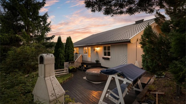 Tomten er opparbeidet med flere uteplasser i terrenget, som her med markterrasse i tre.