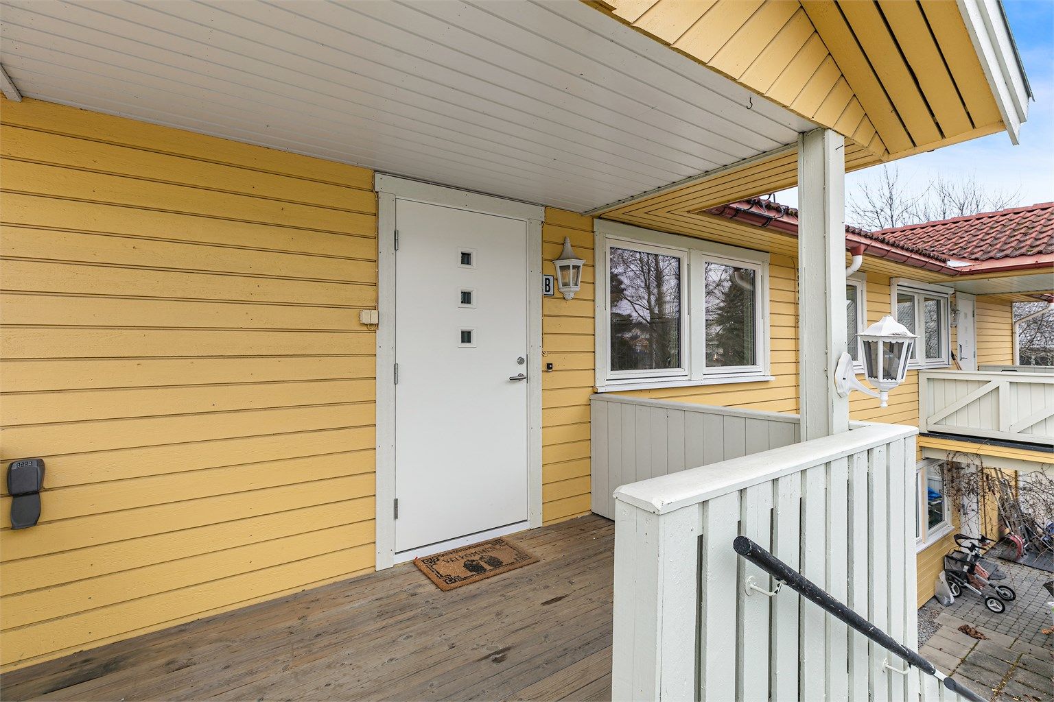 Overbygget inngangsparti med en liten balkong. 