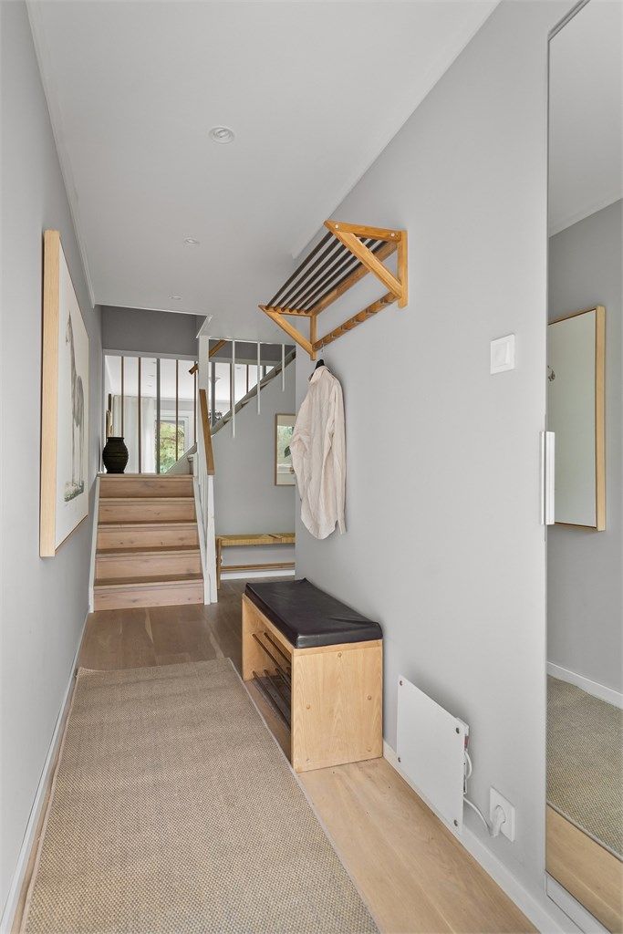 Innbydende inngangsparti med enstavs eikeparkett på gulvet og downlights i himling