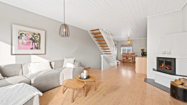 Stuen har heltre gulvbord og et ildsted som gir god varme og atmosfære.