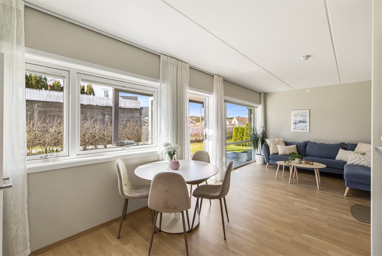 Den åpne løsningen mellom kjøkken og stue skaper en sosial og luftig atmosfære.