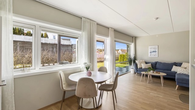 Den åpne løsningen mellom kjøkken og stue skaper en sosial og luftig atmosfære.