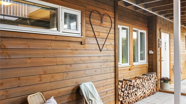 Flislagt areal utenfor inngangsdøren med plass til en koselig sittegruppe.