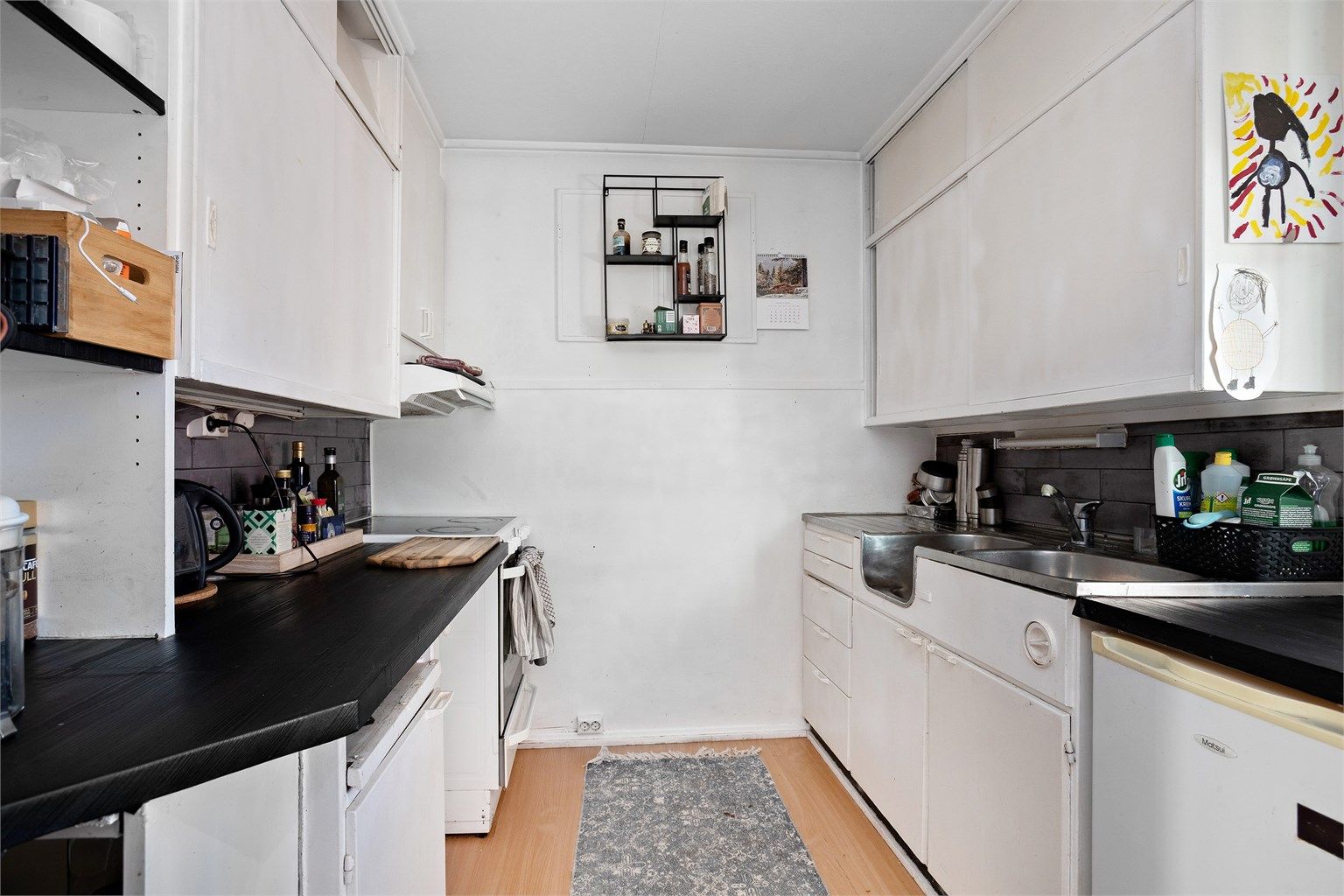 Kjøkkenet i utleiedelen har innredning med glatte fronter, benkeplater av tre og benkeplate av rustfritt stål med nedfelt oppvaskkum.