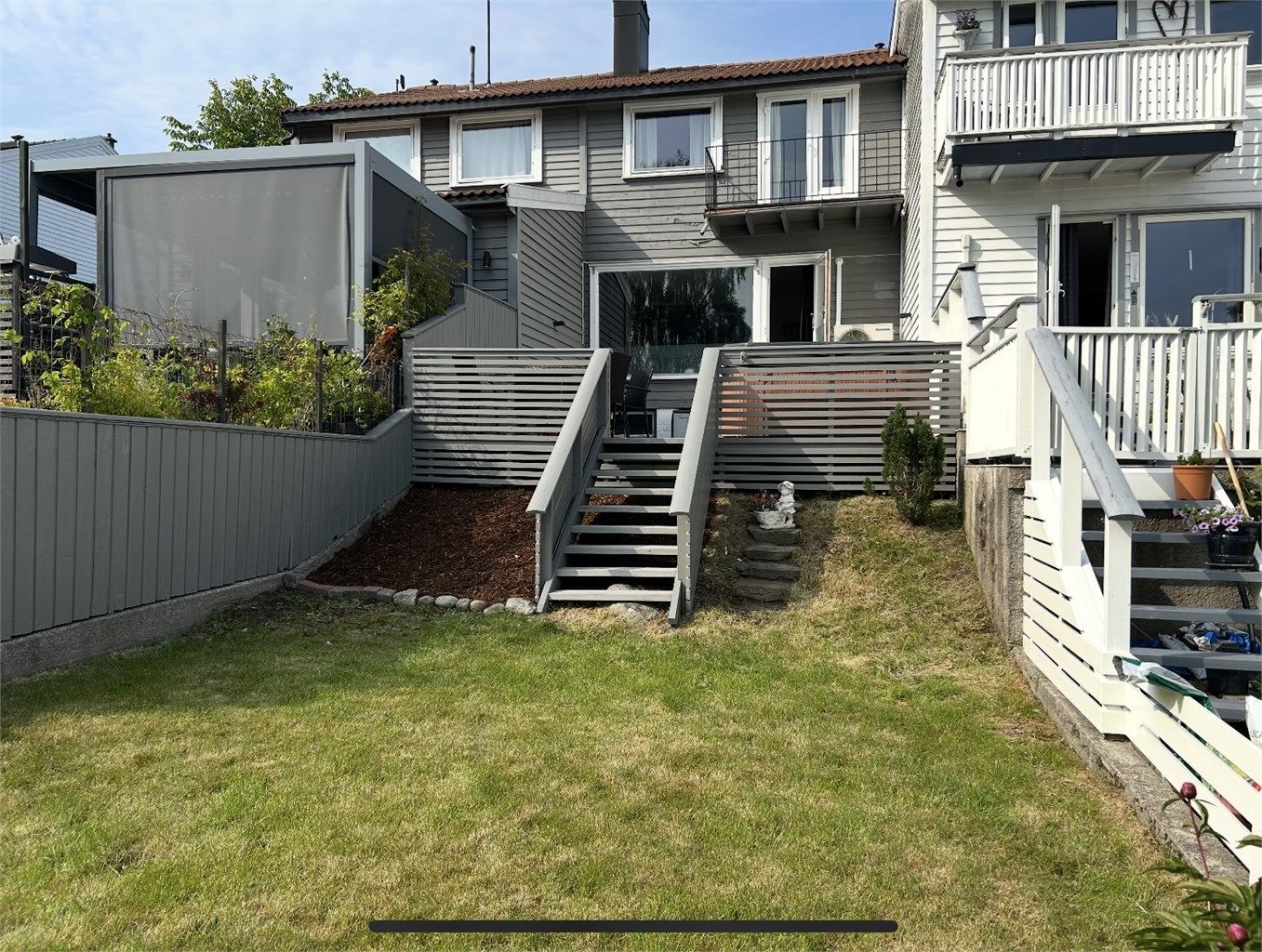 Fasade med hage og terrasse.