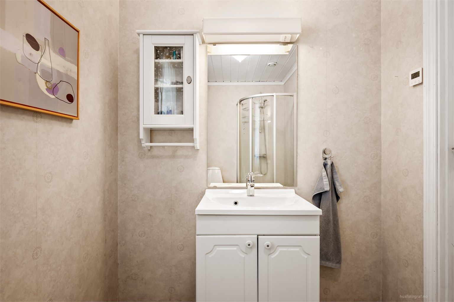 Badet har gulvbelegg med gulvvarme og tapetserte vegger.