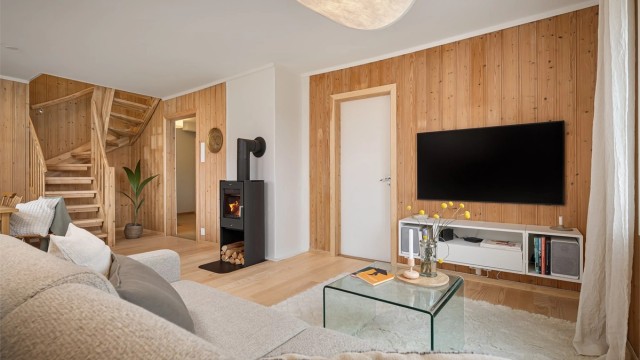 Rommet har en moderne peisovn fra 2025 som fungerer som et møbel i seg selv samtidig som den generer god varme