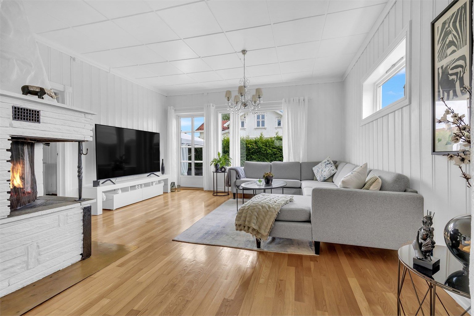 Lys og trivelig stue med god plass til sofagruppe og spisebord. Store vindusflater gir rikelig med naturlig lys, og rommet har parkett på gulv.