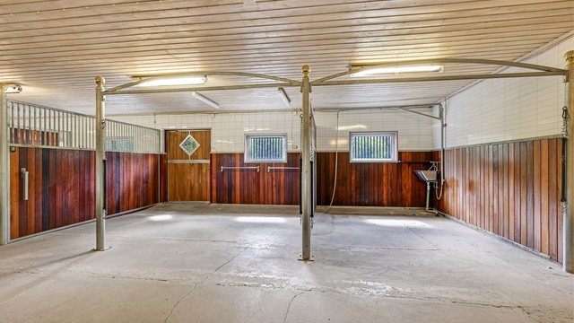 Her finner du en moderne og innbydende stall med totalt syv stallbokser, i tillegg til fôrlager og et praktisk salrom.