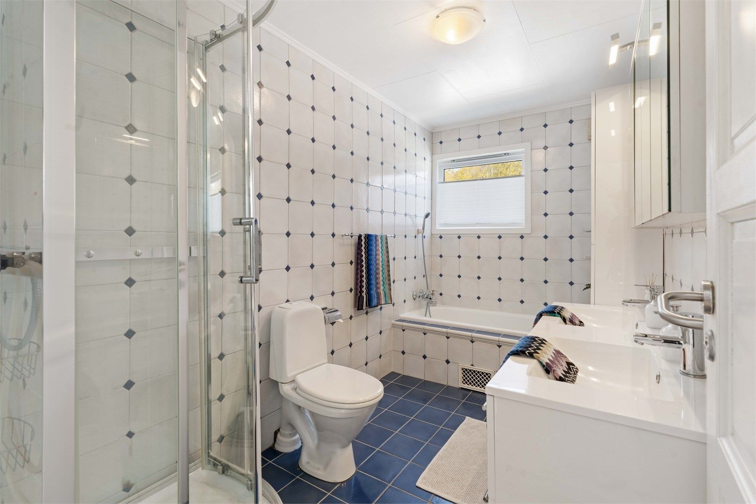 Badet i første etasje er utstyrt med både dusjkabinett og badekar.