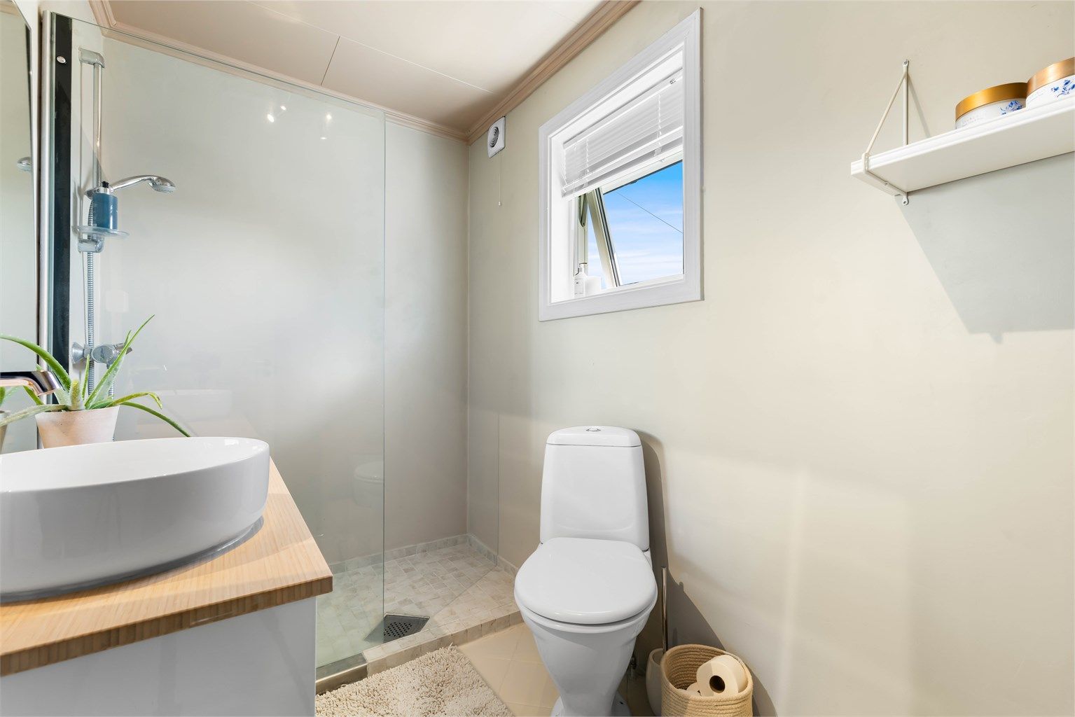 Badet i første etasje har dusjnisje med glassvegg og vegghengt servantinnredning.