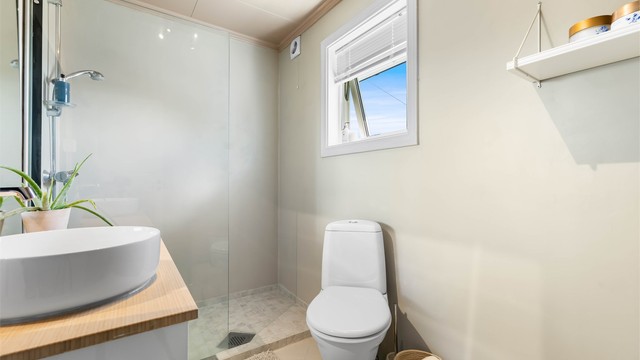Badet i første etasje har dusjnisje med glassvegg og vegghengt servantinnredning.