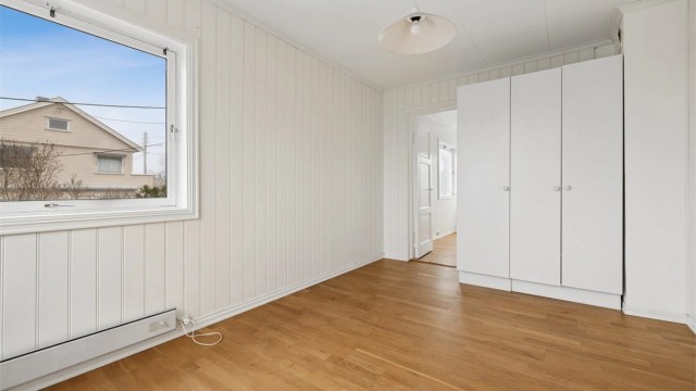 Det ene soverommet i første etasje har laminatgulv og garderobeskap.