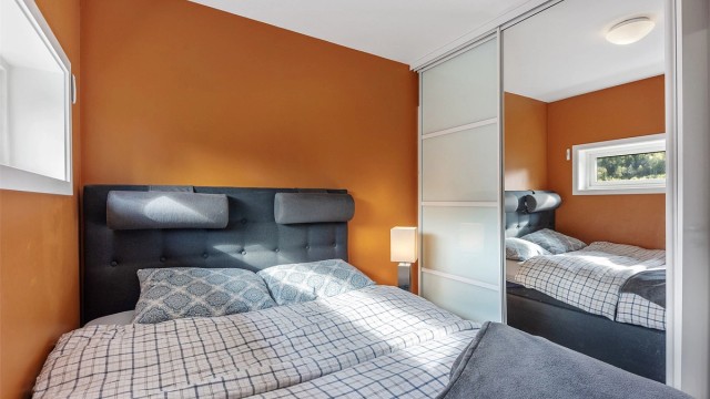 Også her er det en praktisk skyvedørsgarderobe for effektiv oppbevaring.