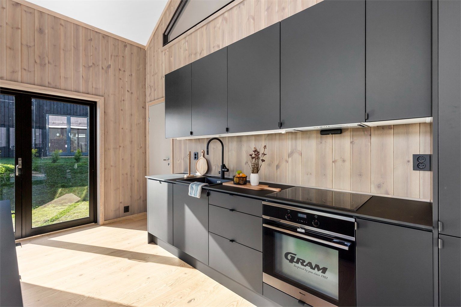 RAKTISK OG PENT: Den mørkegrå innredning bidrar til å veie opp for mye treverk i hytta for øvrig.