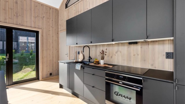 RAKTISK OG PENT: Den mørkegrå innredning bidrar til å veie opp for mye treverk i hytta for øvrig.