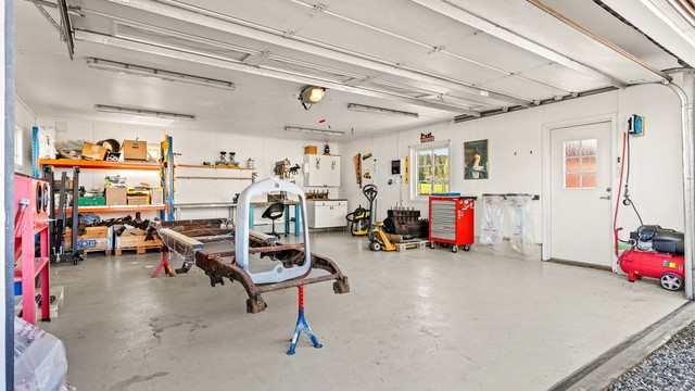 Stor, oppvarmet garasje med god plass til både bil og hobbyprosjekter. Ladepunkt for elbil er montert på ytterveggen.