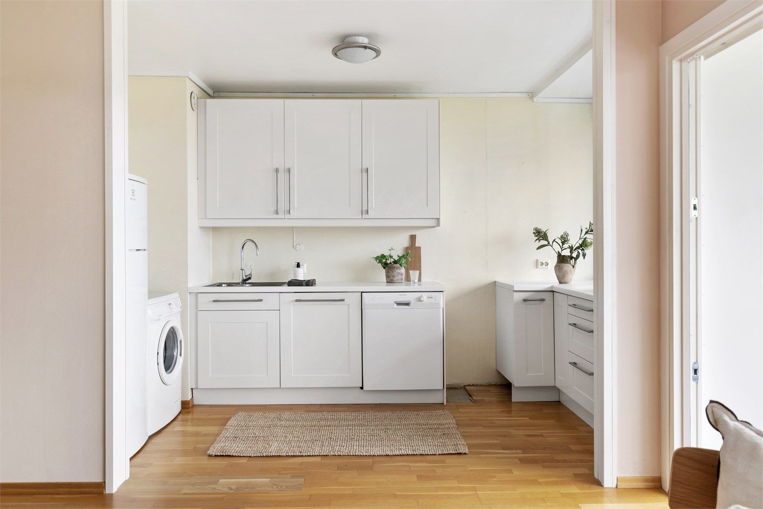 Kjøkkeninnredning med profilerte fronter og benkeplate med laminert overflate. Kjøkkenet har nedfelt vask med armatur samt benkeskapsbelysning.
