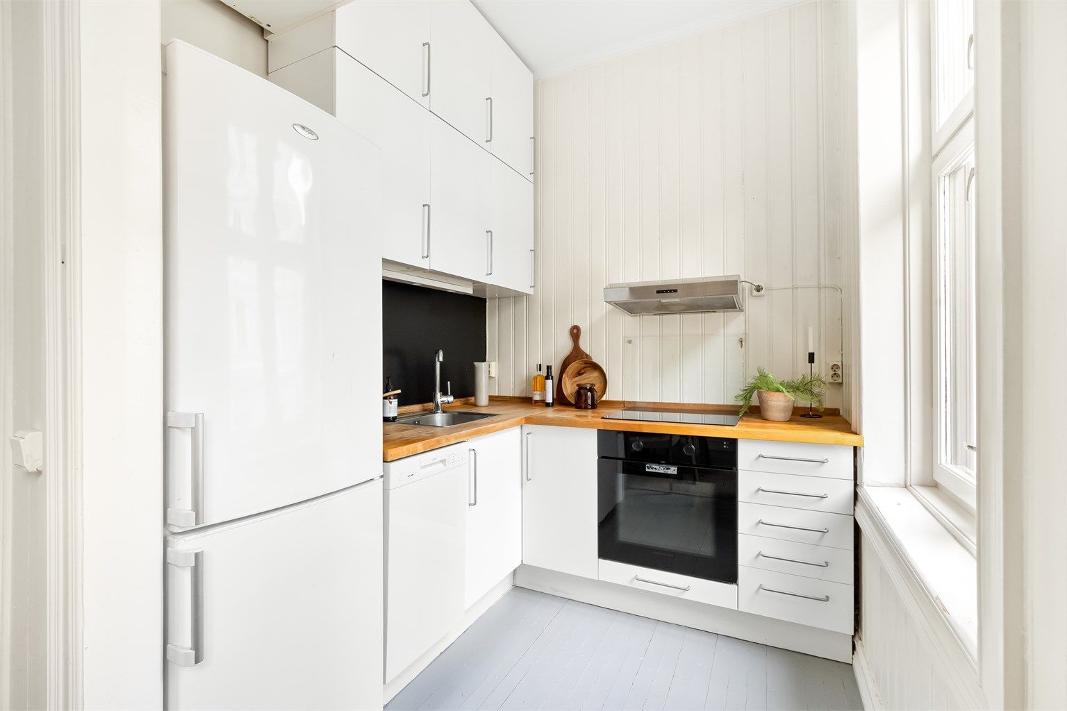 Innredningen har glatte fronter og benkeplate i treverk med oppvaskkum.