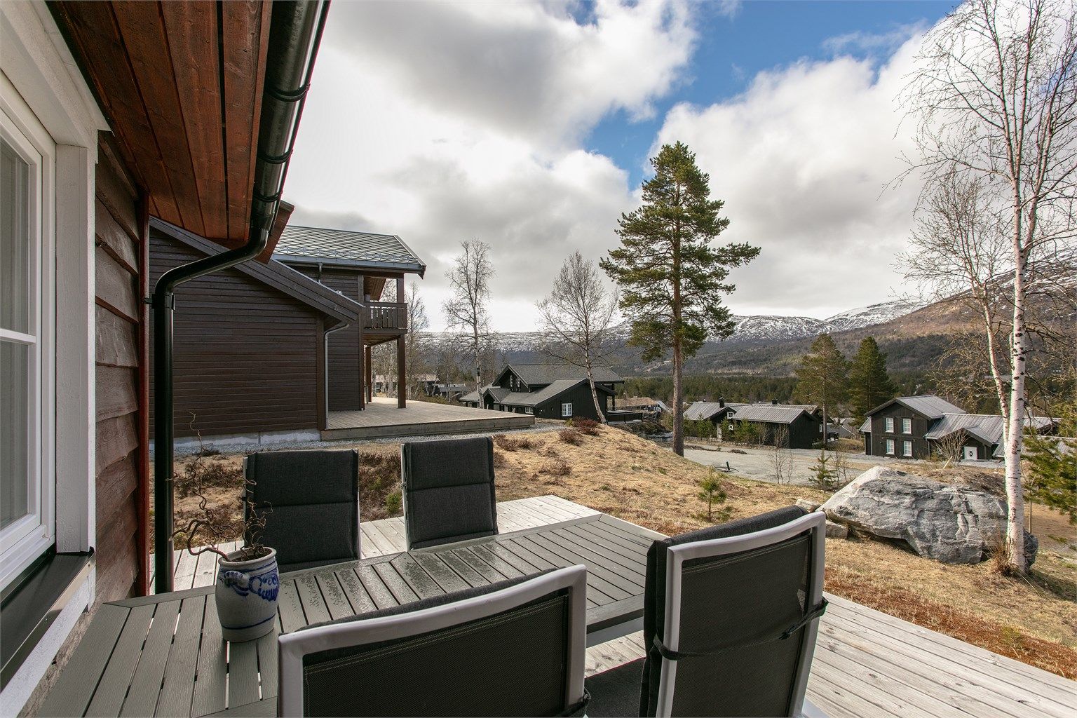 Fra uteplassen har man utsikt over hyttefeltet og fjellene rundt.