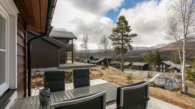Fra uteplassen har man utsikt over hyttefeltet og fjellene rundt.