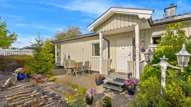 Steinlagt uteplass ved inngangspartiet med god plass til sittegruppe.