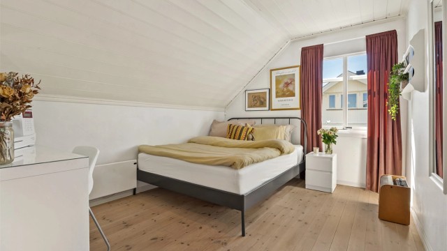 Et av tre soverom i andre etasje. Rommet har heltre gulvbord og panelbord i himlingen.