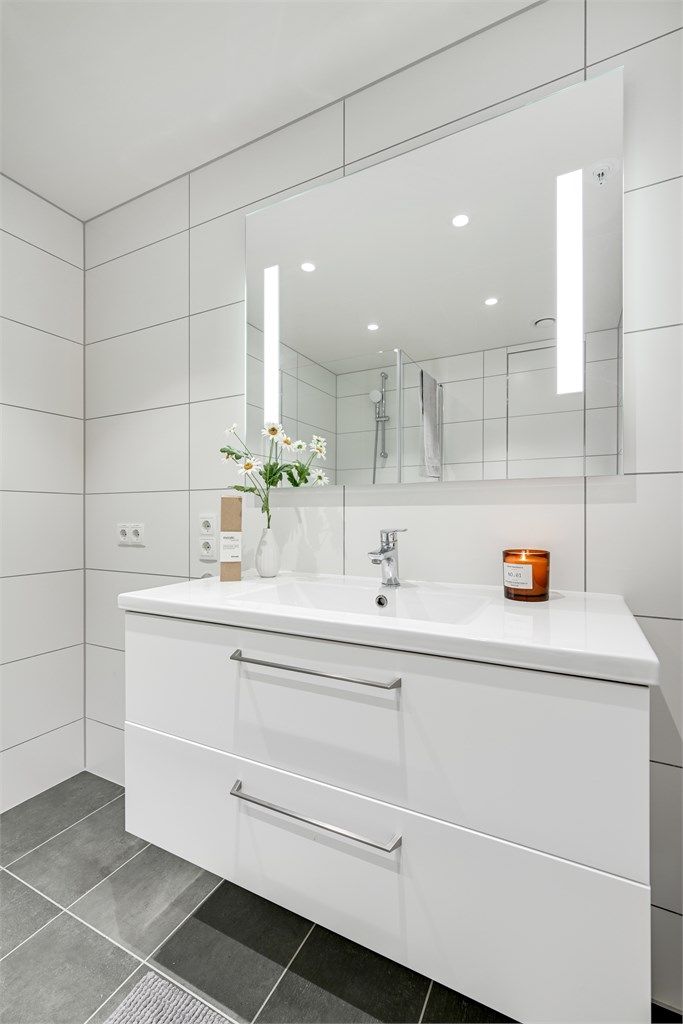 Badet er er innredet med servant i innredning og vegghengt toalett.