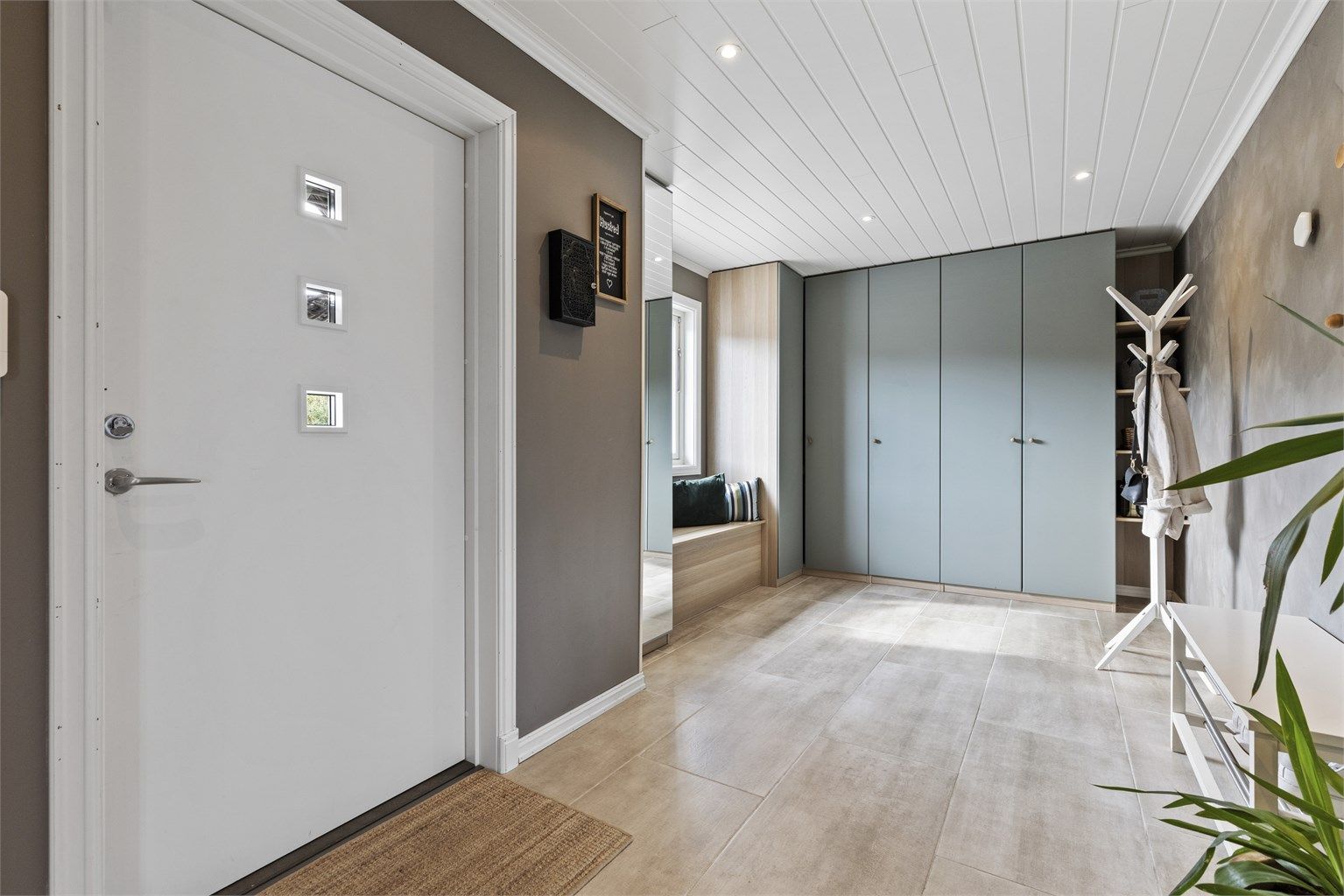 En innbydende start på hjemmet, med fliser, varme i gulvet og god plass til yttertøy. Foto Marika Foto AS

