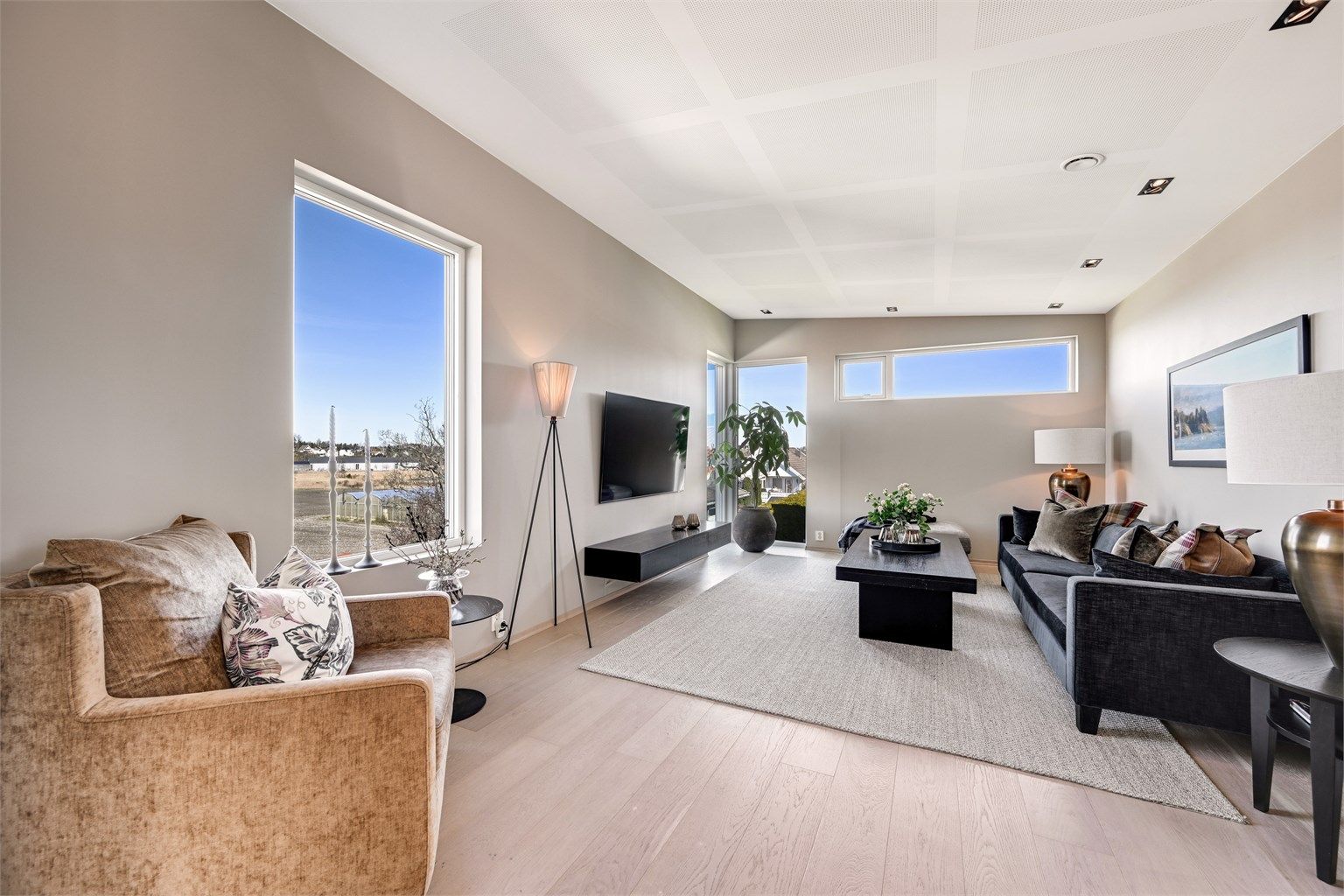 Stuen har parkett på gulvet og store vindusflater som gir rikelig med lys og utsyn.