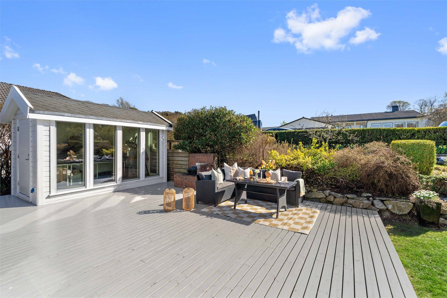 Den romslige tomten byr på store, solrike uteområder med flere terrasser, hagestue og god plass.