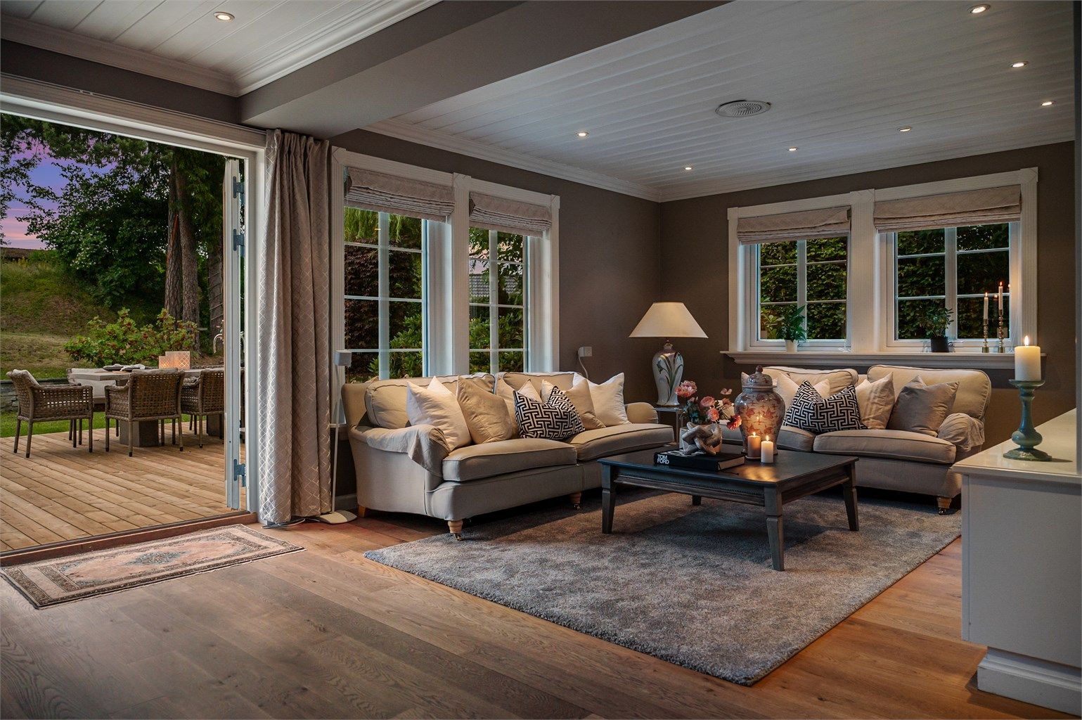 Kveldsstemning i stuen med doble dører ut til hagen. 