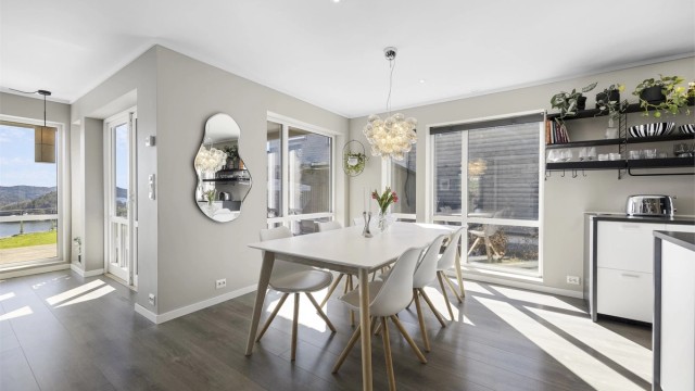 Spisestuen har god plass til langbord og er plassert med utsikt mot fjorden.