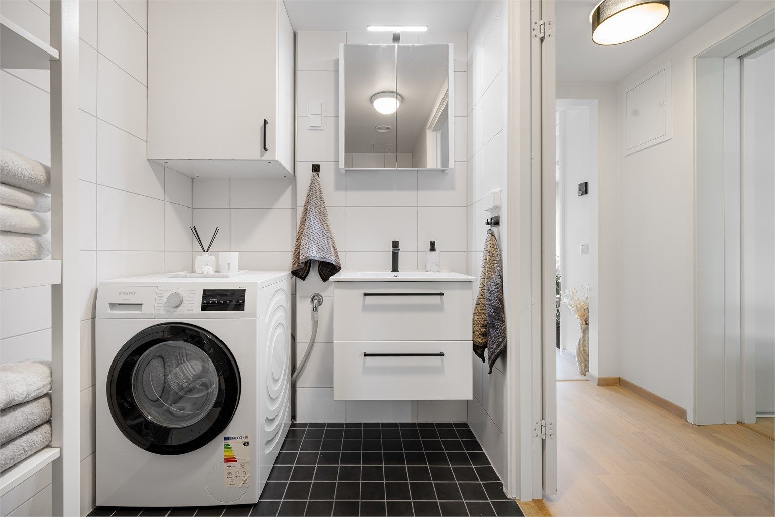 Praktisk innredet med vegghengt servantinnredning og baderomsmøbel, samt speilskap med overlys og stikkontakt over servant.