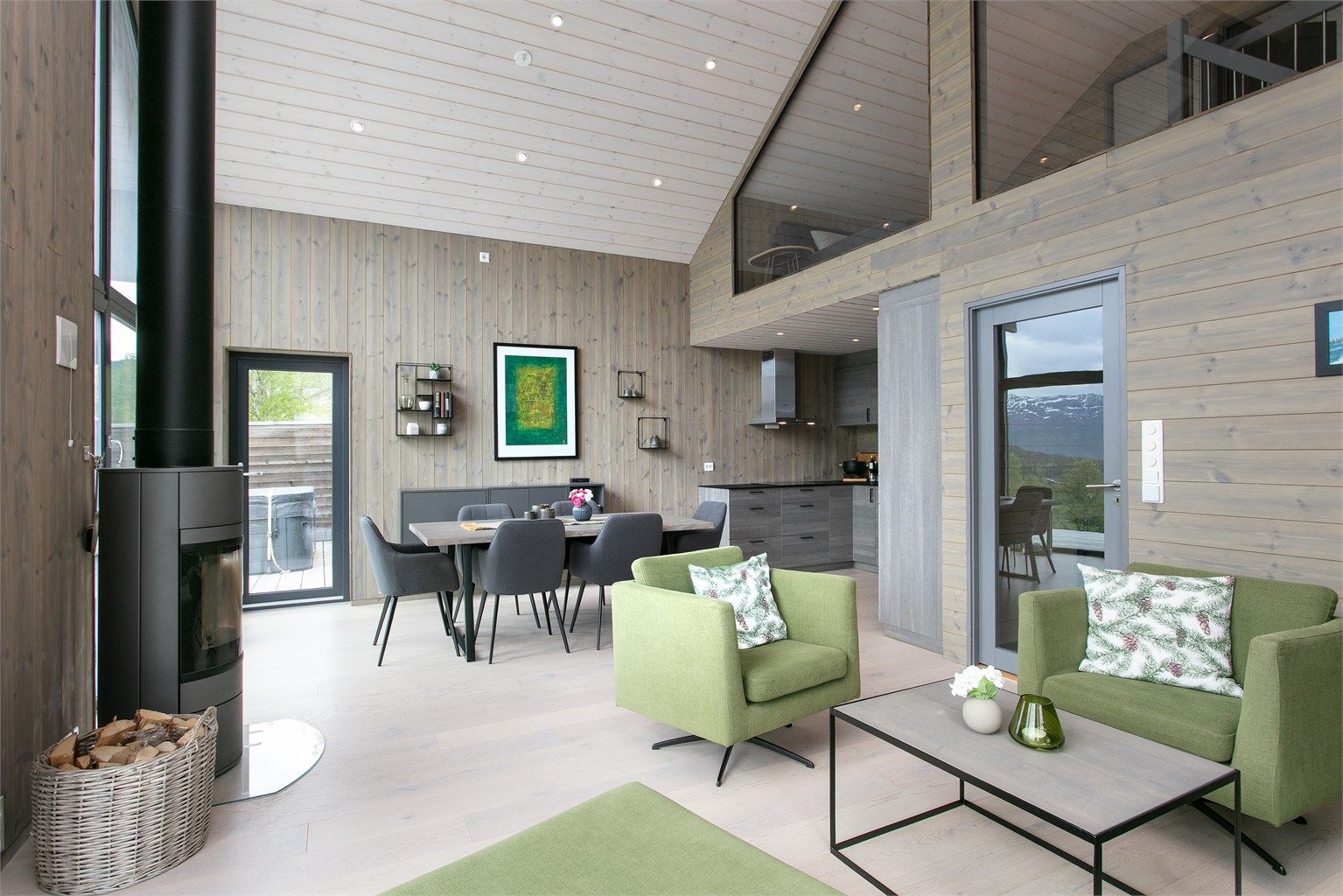 Den åpne løsningen gir god plass til både sofagruppe og spisebord, med glassvegg mot loftsetasjen.
