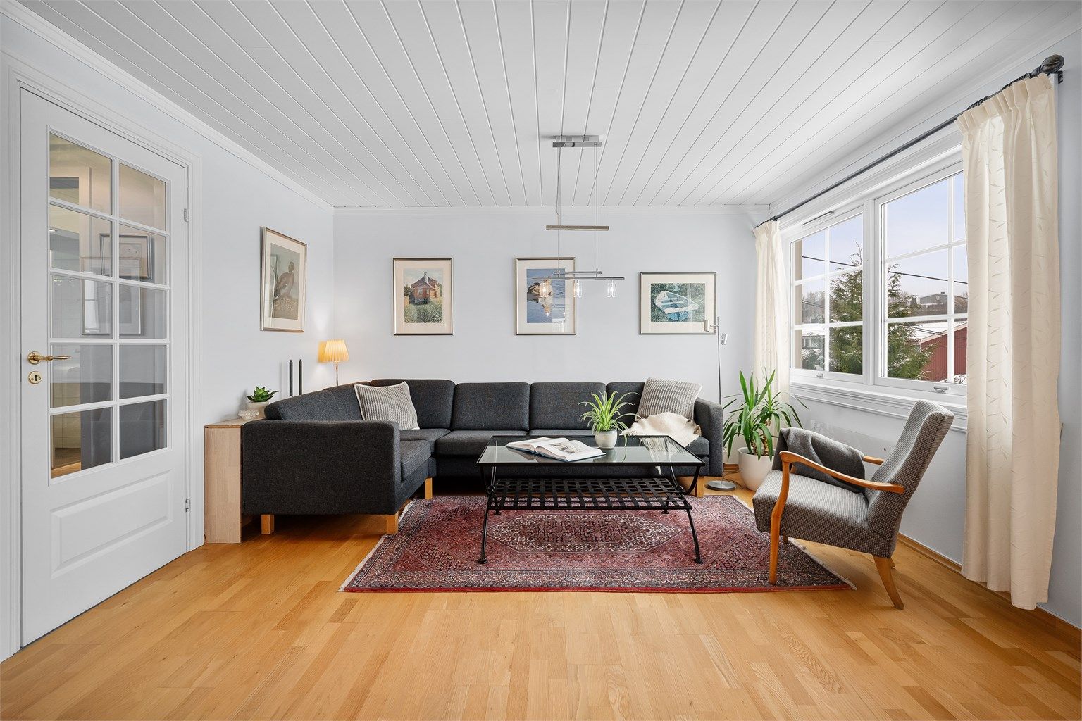 Stuen er et lyst og romslig samlingspunkt med parkett på gulvet og god plass til sofagruppe.