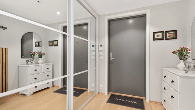 Velkommen inn i en romslig entré med god plass til yttertøy og sko bak en stor skyvedørsgarderobe/bod. Her er det også dørcallinganlegg.