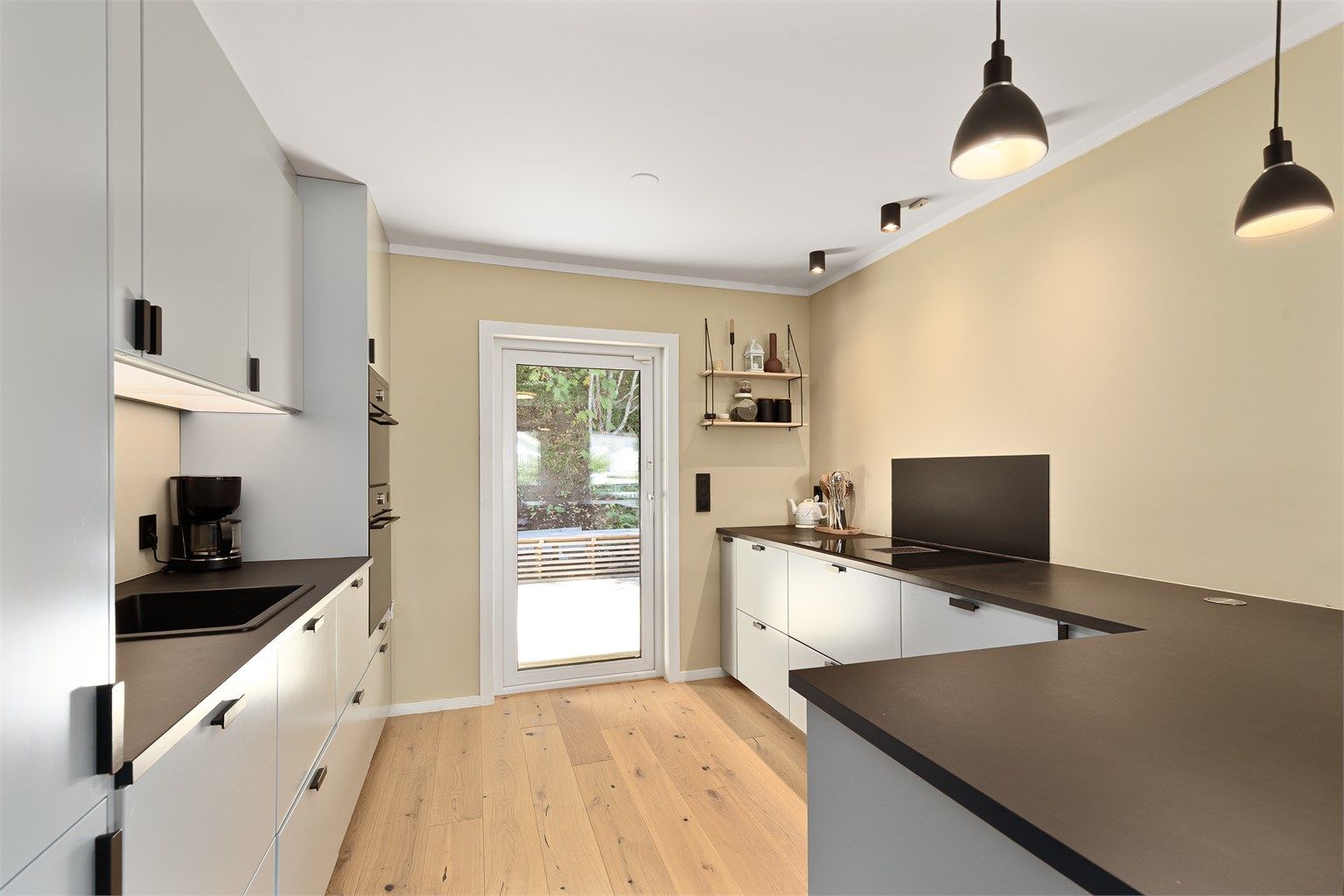 Glatte fronter, laminert benkeplate og glassplate montert bak vask og platetopp.