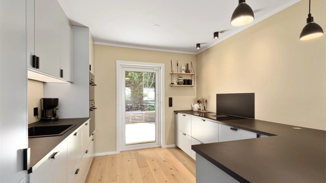 Glatte fronter, laminert benkeplate og glassplate montert bak vask og platetopp.