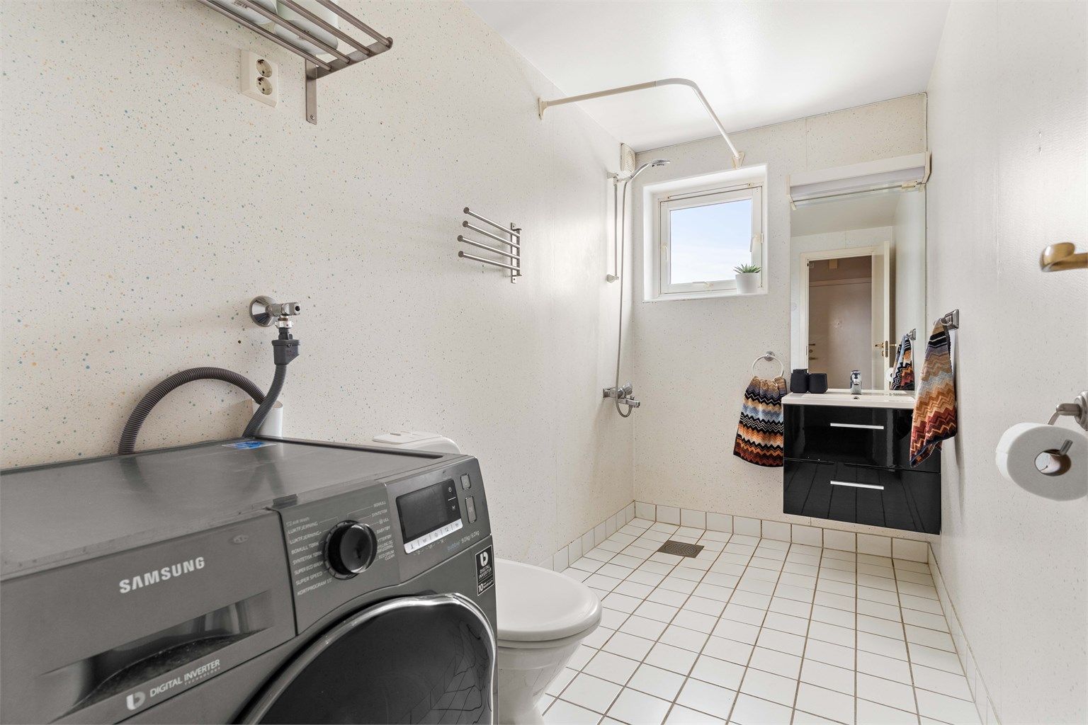 Her er det også gulvmontert toalett og praktisk opplegg for vaskemaskin.