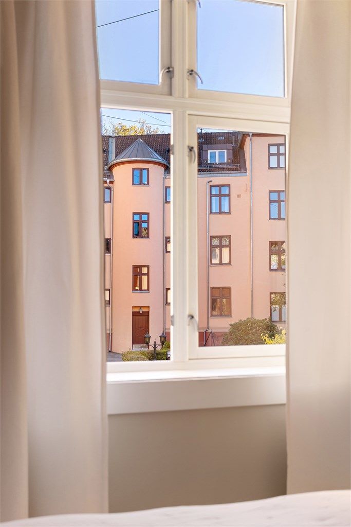 Det store vinduet vender mot en rolig bakgård og bidrar til en skjermet atmosfære med begrenset innsyn