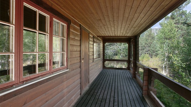 Fra verandaen har du utsikt mot furuskogen og det omkringliggende terrenget.