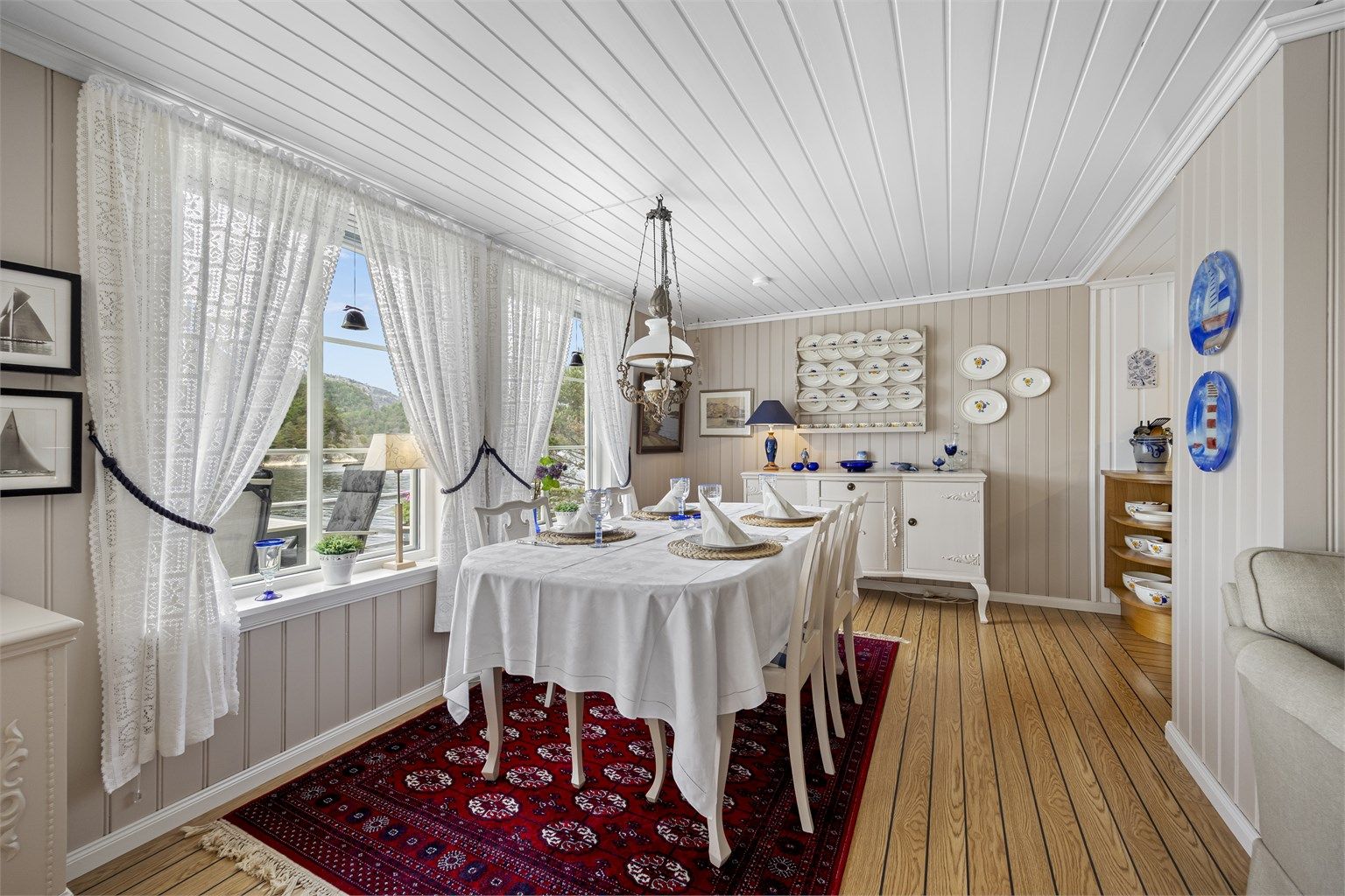 Stuen har god plass til en egen spisedel, med utsikt mot sjøen.