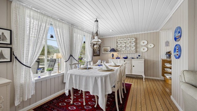 Stuen har god plass til en egen spisedel, med utsikt mot sjøen.