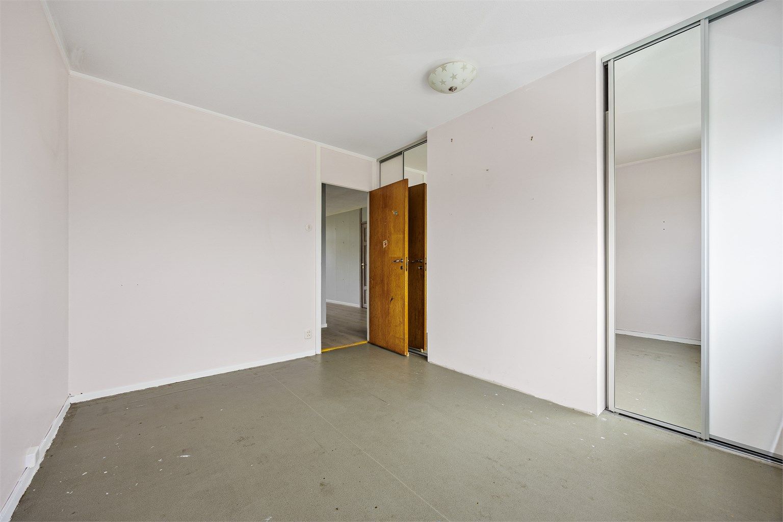Hovedsoverom med stor skyvedørsgarderobe for effektiv oppbevaring.