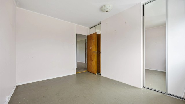 Hovedsoverom med stor skyvedørsgarderobe for effektiv oppbevaring.