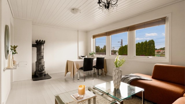 Stuen har gulv belagt med gulvbord og det er montert vedovn. Perfekt for varme på ekstra kjølige dager.
