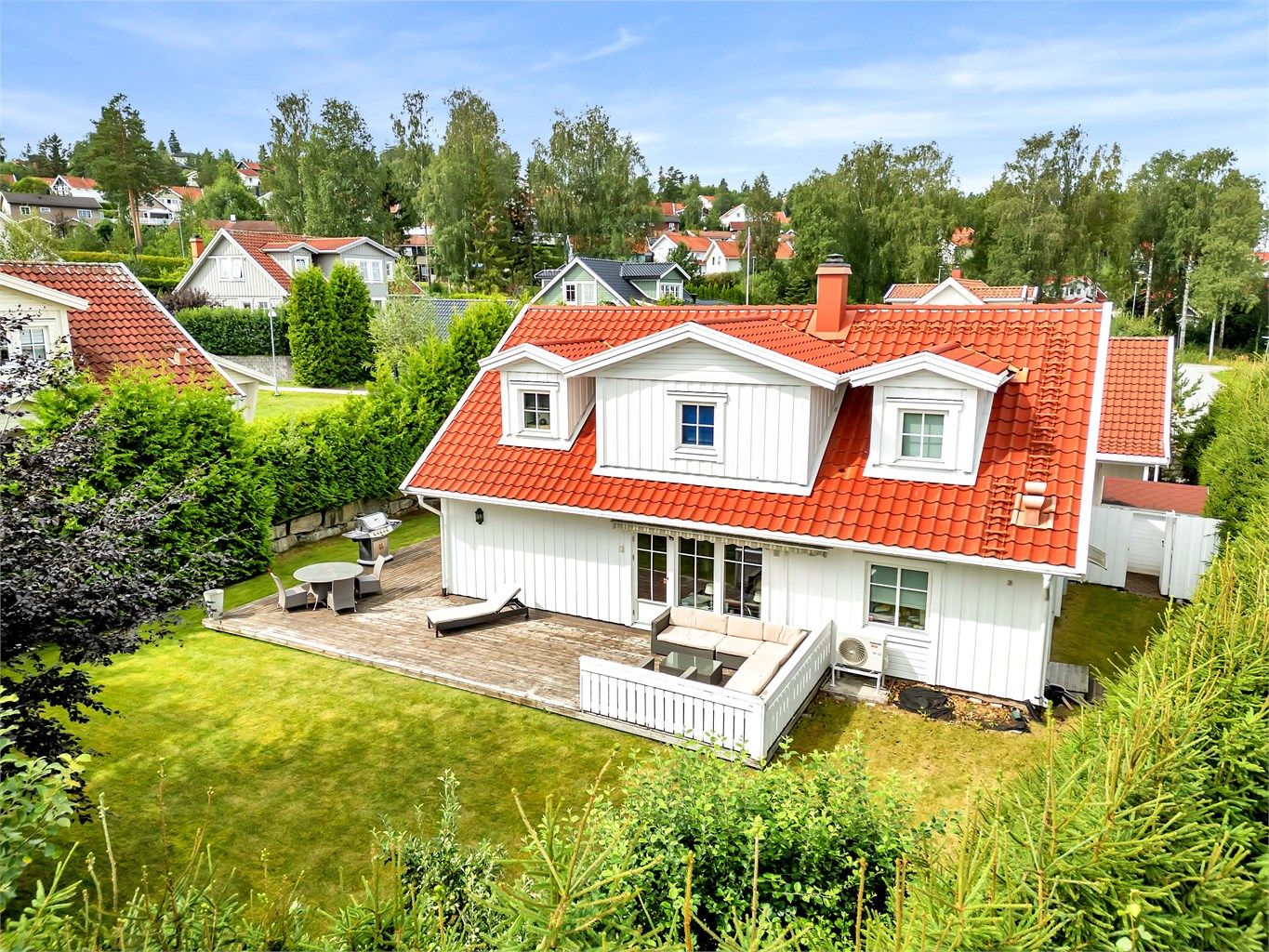 Velholdt uteområde med solrik terrasse, plen og skjermede soner rundt boligen.