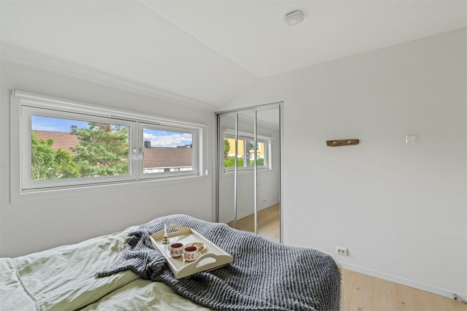 Soverom i 2. etasje med skyvedørsgarderobe med speilfronter.